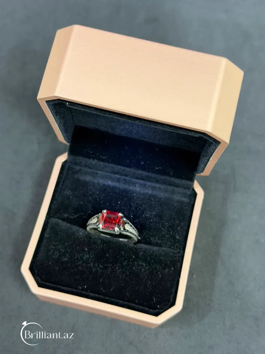 Серебряное мужское кольцо с ограненными камнями и узорчатыми боковыми сторонами.