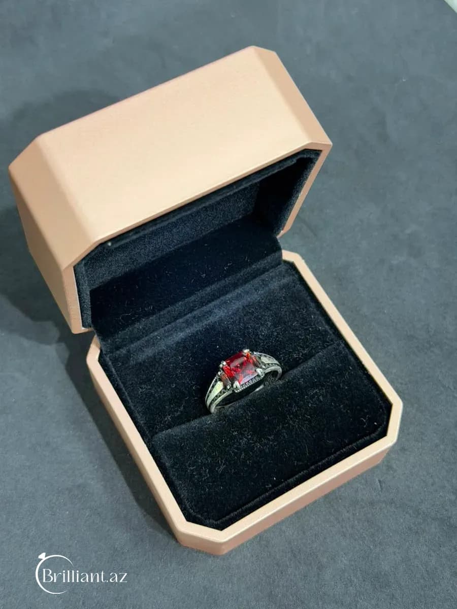 Серебряное мужское кольцо с ограненными камнями и узорчатыми боковыми сторонами.